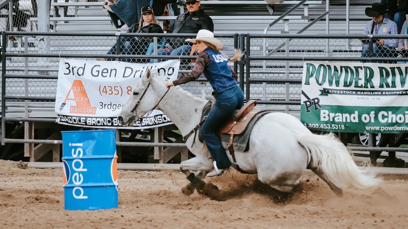 USU Rodeo Club member riding a horse in the arena.