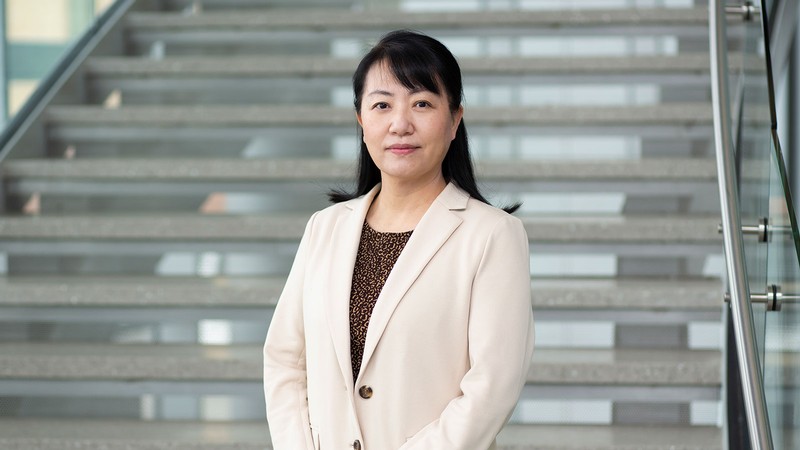 Rose Hu stands in front of a staircase.
