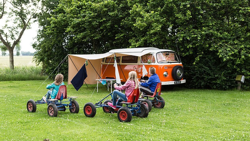 kids playing near a camper in a campground.