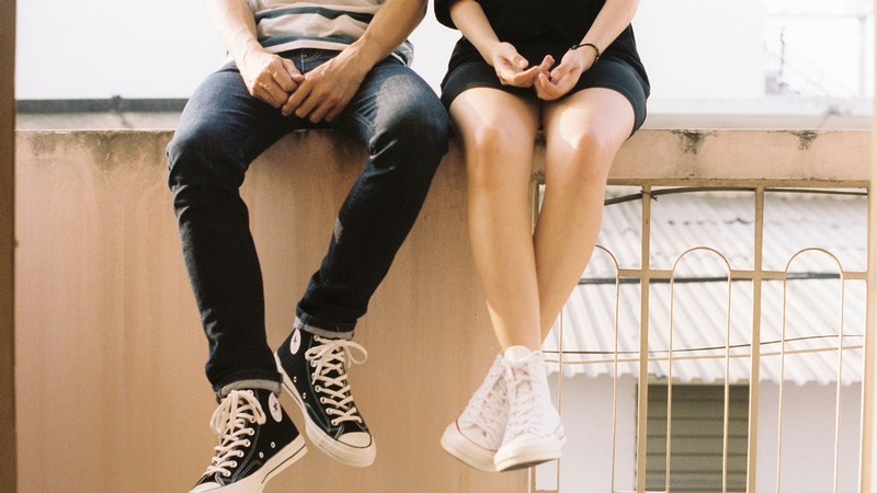 Two teens sitting next to each other.