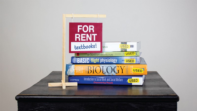 text books in a pile on a table.