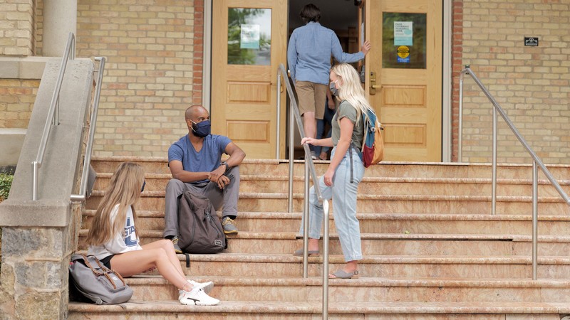 Students sitting on Old Main steps.