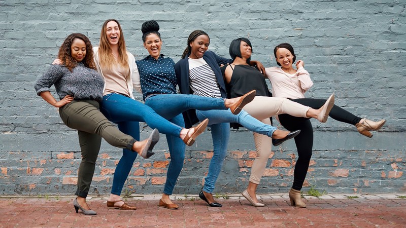 A group of women joining hands.