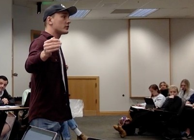 A person speaking in a classroom.