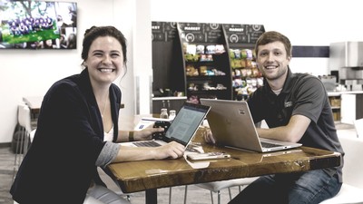 Two employees work at a table.