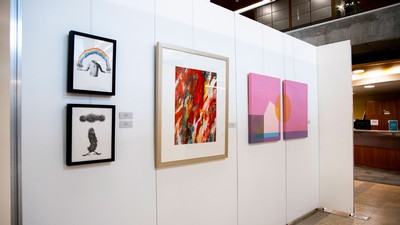 Paintings hang on an exhibit wall at the Merrill-Cazier Library at USU in Logan.