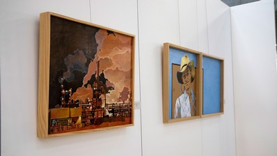 Paintings hang on an exhibit wall at the Merrill-Cazier Library at USU in Logan.