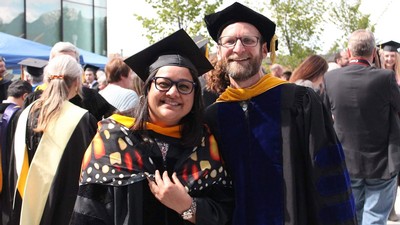 Samridhi Chaturvedi and Zach Gompert wearing graduation robes.