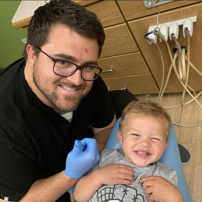 Kolby Lance gives a thumbs up while his son Rowan sits in his dentist's chair.