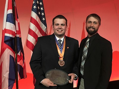 Two men with an award plaque.