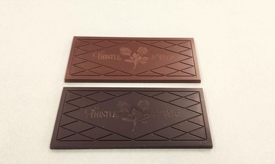 A chocolate bar next to a slightly darker bar.