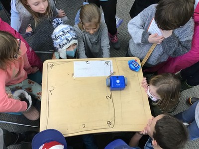 Children around a table with robotics equipment.