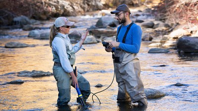 Researchers wading in a river.