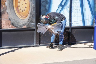 A welder cuts a metal ribbon.