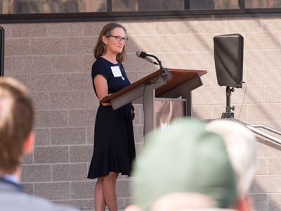 A woman stands at a pulpit to address a crowd.