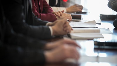 Businesspeople sit around a table.