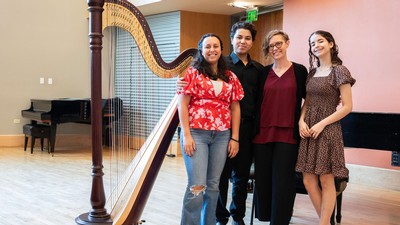 People standing by a harp.