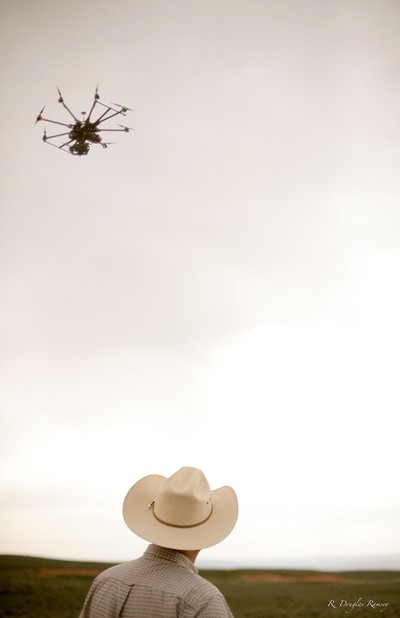 A farmer looking at a drone.