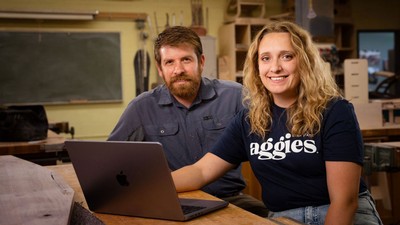 Joe Furse and Hannah Lloyd sitting at a laptop.