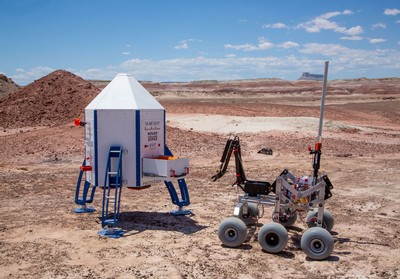 A robotic rover approaching a mock lander as part of the Rover Challenge Series.