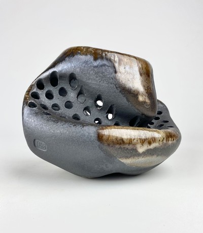 A ceramic sculpture with an abstract shape.