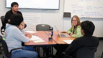 A teacher meeting with three students.