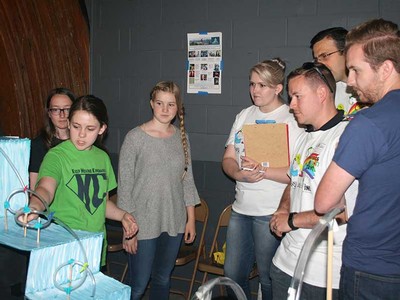 Teens with amusement park ride model.