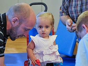 a client and technicians at the Assistive Technology Center in Roosevelt