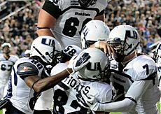 USU football players on field, celebration