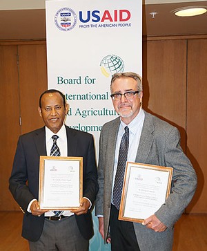 USU professor Layne Coppock and USU research associate Getachew Gabru with their awards