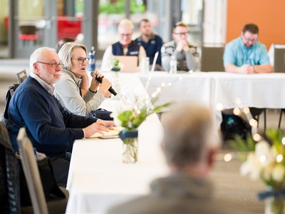 A group of people sit at a table in a discussion.