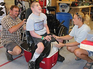 an adapted saddle with client and staff at tje Assistive Technology Center in Roosevelt, Utah