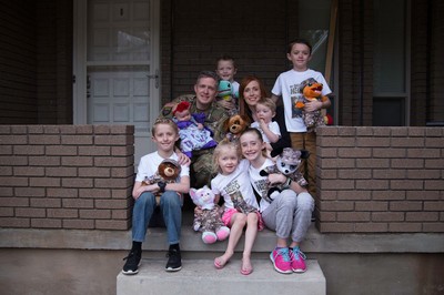 Brent and Jennie Taylor on a porch with their seven children.