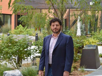 David Feldon standing outside near a garden.