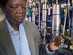 USU USTAR professor Dr. Foster Agblevor in his lab holding a small piece of bio-based plastic