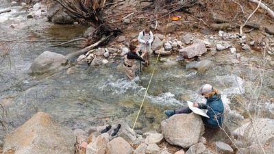 Belize Lane collecting streamflow data with grad student Haley Canham.