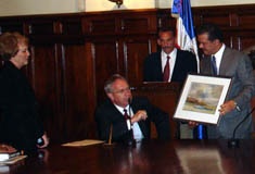 President Stan Albrecht presents a painting by former Utah State faculty member Harrison Groutage to Dominican Republic President Leonel Fernandez as First Lady Joyce Albrecht looks on. 
