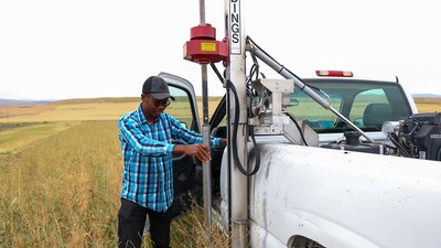 Idowu Atoloye looking over equipment while out in the field.