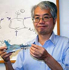 USU chemistry professor Tom Chang with a paper model of a military jet