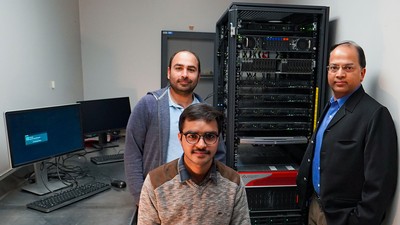 Researchers Naveen Duhan, Kartik Saini and Rakesh Kaundal pose in front of a computer server.