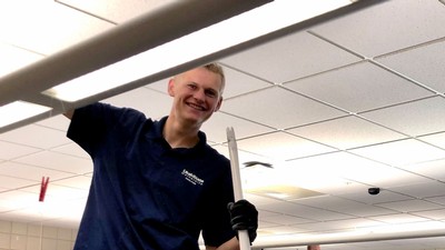 USU Facilities employee installing and LED light.