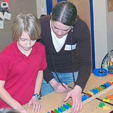 Linsey Johnson with a child for science activity