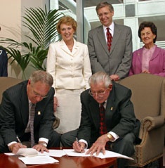 Utah State University President Stan Albrecht and Lorenzo N. Hoopes, executor of the Ray and Eloise Lillywhite estate, sign the gift agreement. First Lady Joyce Albrecht, Vice President for University Advancement M. Scott Mietchen and Marne Tuttle look on.