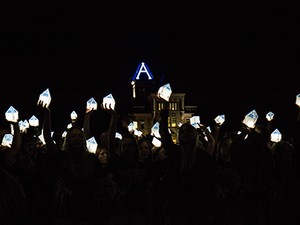 student holding lit luminaries