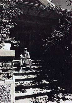 poet May Swenson sitting on the steps of the family home