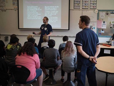 Nursing students Scott Fielding and Mark Weissinger teaching helmet safety.