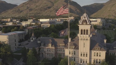 Flag flying in front of Old Main on USU's campus.