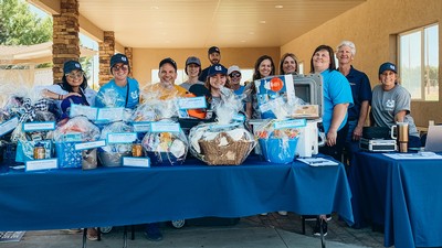 A group of people behind tables with gift baskets