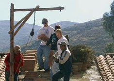Volunteers prepare to tile a roof