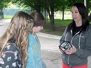 Students at the USU Physics Day at Lagoon looking at a CubeSat